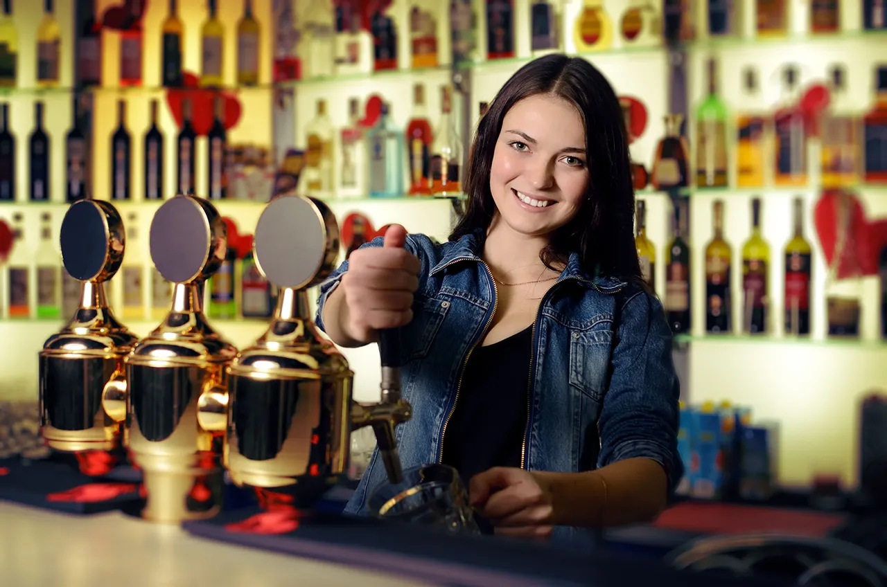 Female bartender pulling beer tap