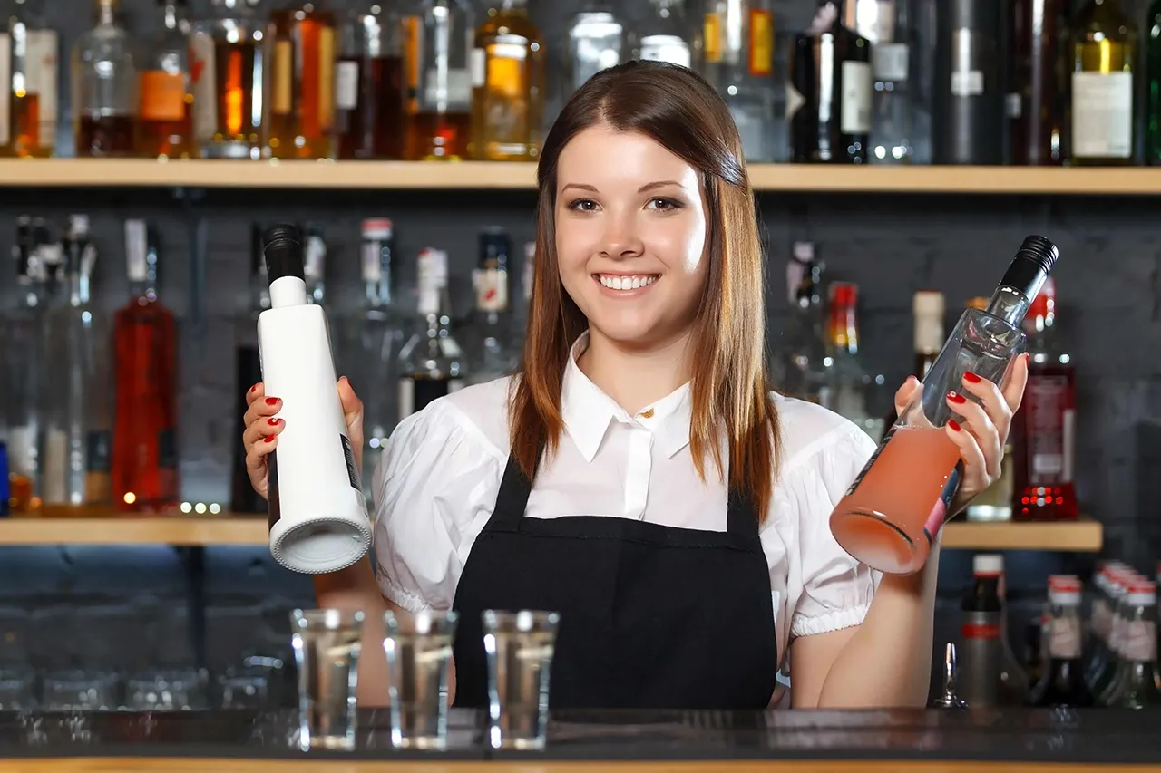 Female bartender holding liquor bottles