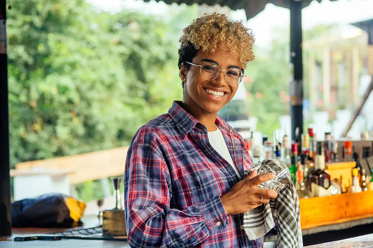 Female African American bartender polishing a glass