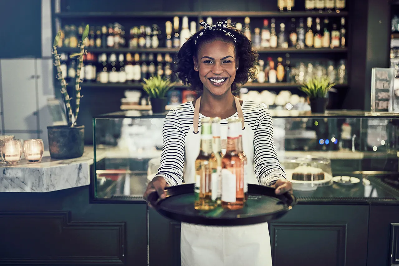 Female African American bartender with wine bottles