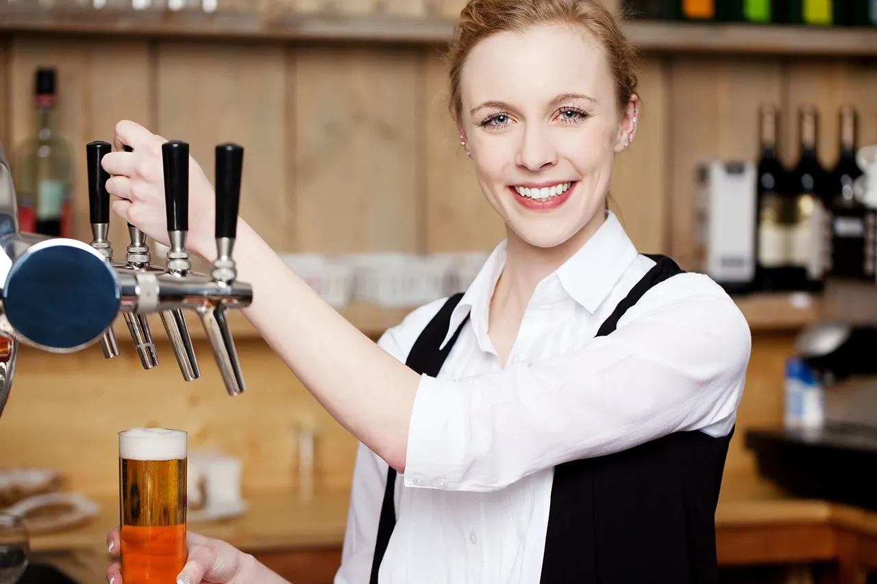 Female bartender pulling beer tap