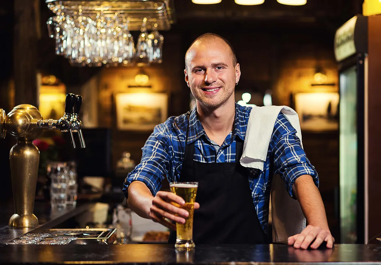 Male bartender with beer glass