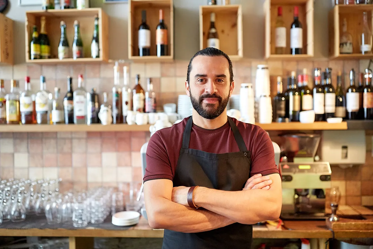 Male bartender in front of bar