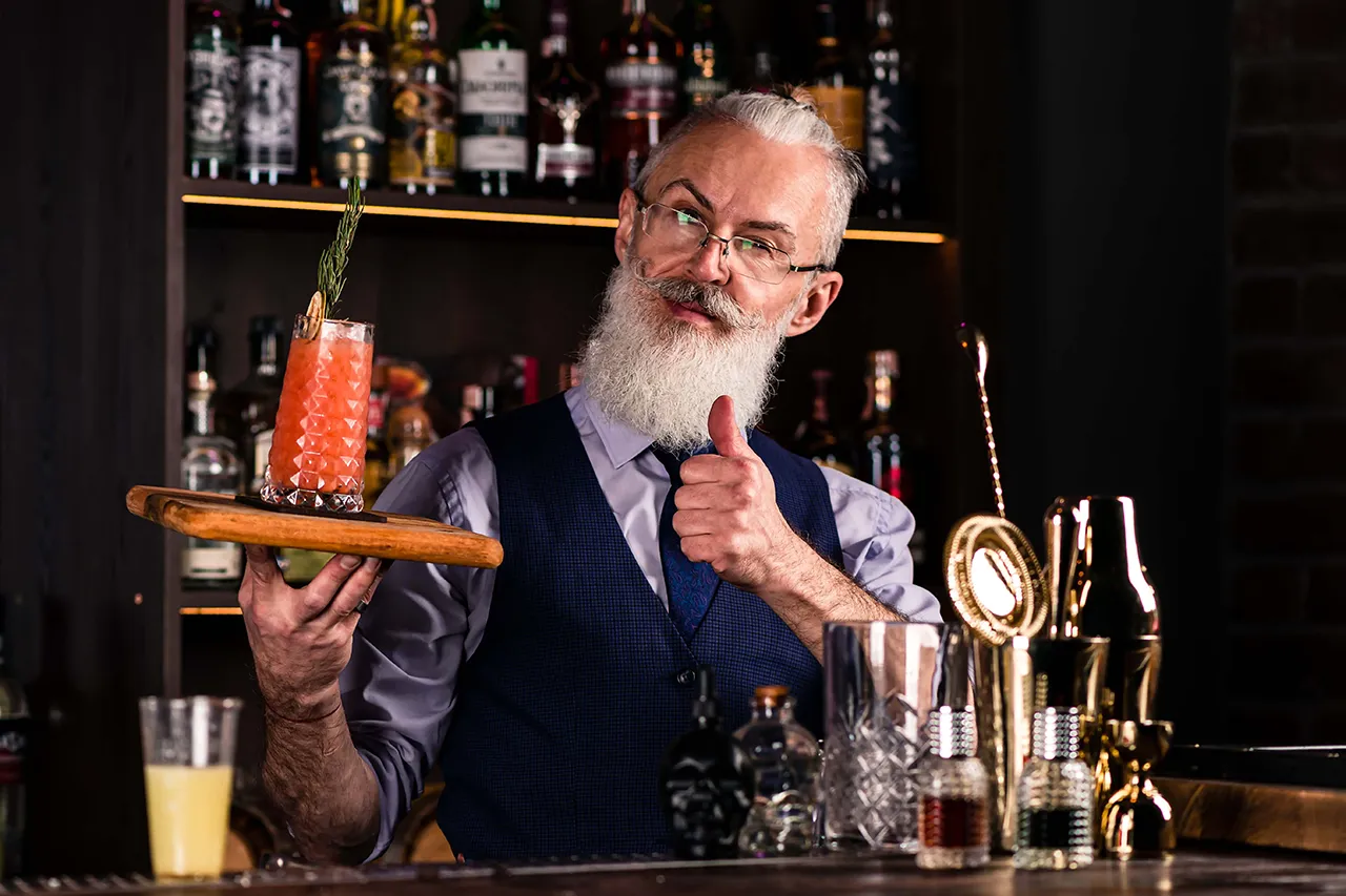 Older male bartender with drink tray